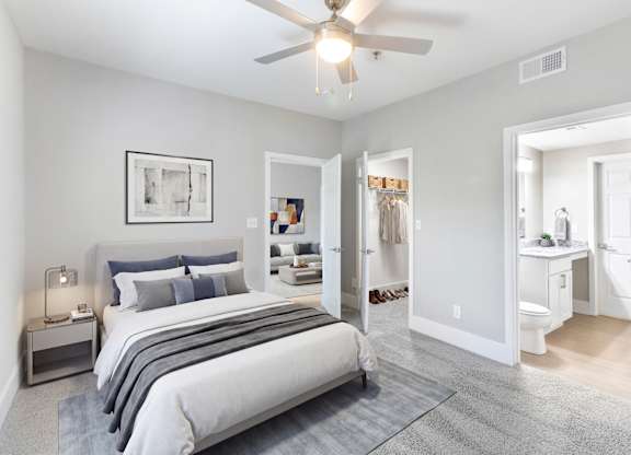 A bedroom with a large bed and a ceiling fan.