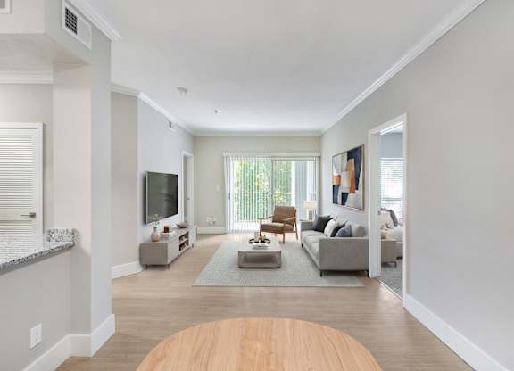 A modern living room with a wooden floor and a grey couch.