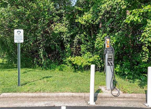 An electric vehicle charging station is located next to a sign that says "ELECTRIC VEHICLE CHARGING ONLY".