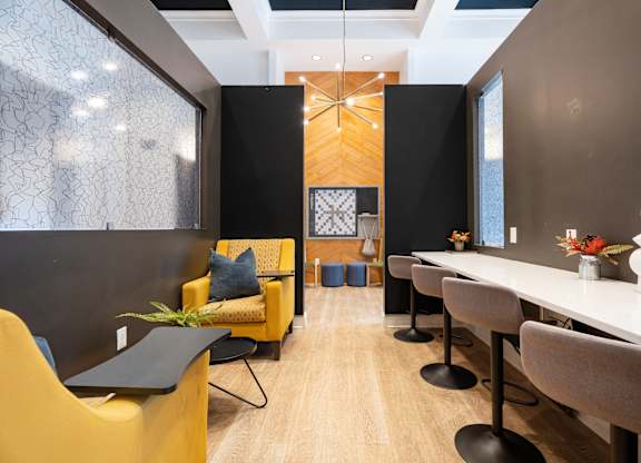A modern dining room with a long table and chairs.