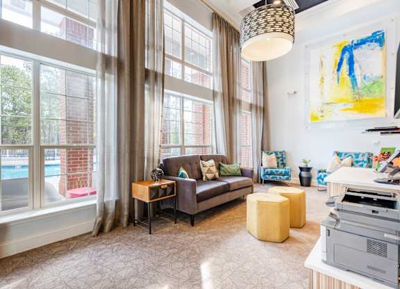 A living room with a couch, a table, and a painting on the wall.