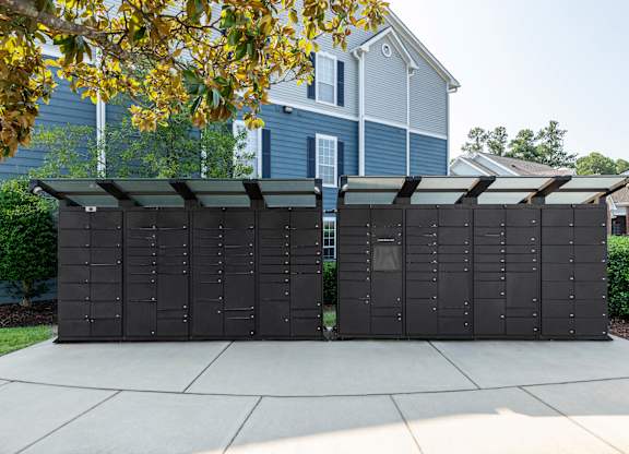 A large black structure with a roof is situated on a concrete slab.
