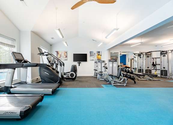 A gym with treadmills, elliptical machines, and other exercise equipment.