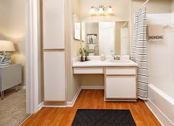 A bathroom with a vanity and a striped shower curtain.