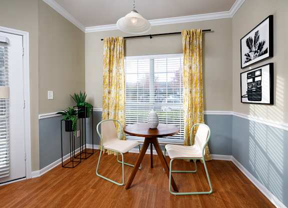 A dining room with a table and chairs.