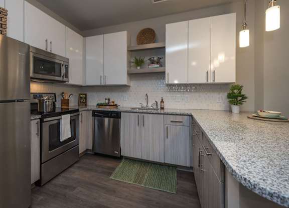 A modern kitchen with stainless steel appliances and white cabinets.