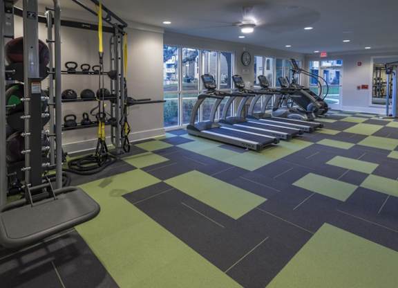 A gym with treadmills, weights, and exercise equipment.