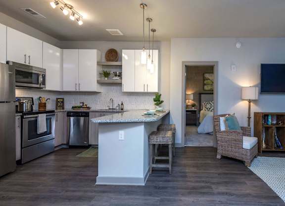 A modern kitchen with a large island and stainless steel appliances.