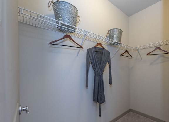 A hallway with a row of hangers and a dress hanging on one of them.
