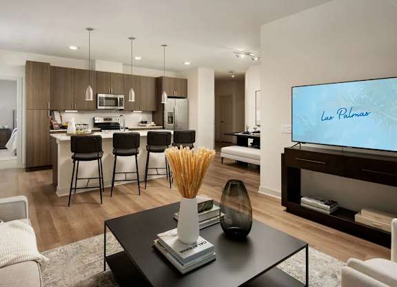 A modern living room with a black coffee table and a flat screen TV.
