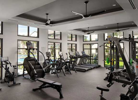A gym with a variety of equipment including treadmills, stationary bikes, and weight machines.