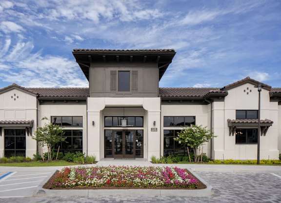 A modern building with a flower bed in front.