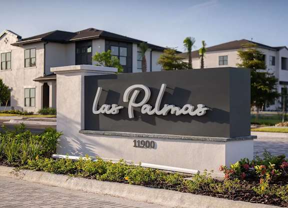A sign for "Las Palmas" stands in front of a row of houses.
