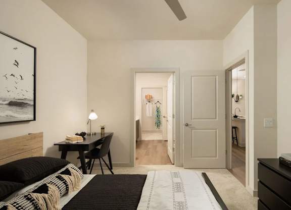 A bedroom with a bed, desk, and chair.