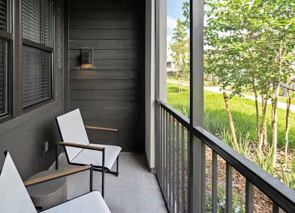 A balcony with a chair and a table.