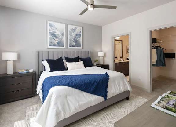 A bedroom with a large bed and a ceiling fan.