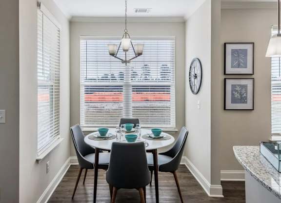 A dining room with a table set for four.