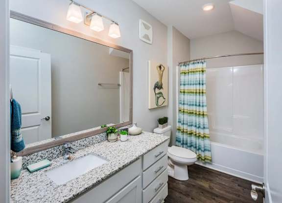 A bathroom with a white sink and a white toilet.