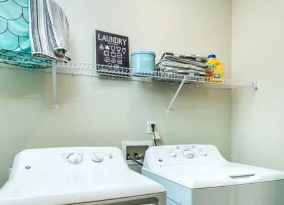 Two white front loading washing machines in a laundry room.