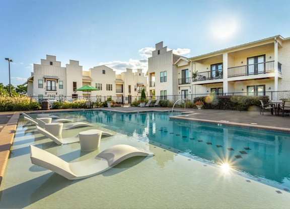 A sunny day at a modern apartment complex with a pool.