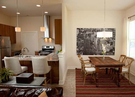 A kitchen with a dining table and chairs.