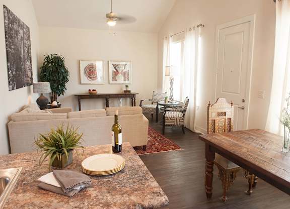 A living room with a couch, a table, and a plant.