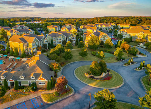 A large, well-maintained residential complex with a swimming pool and a roundabout.