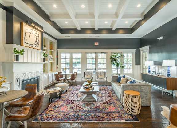 A living room with a fireplace and a rug on the floor.