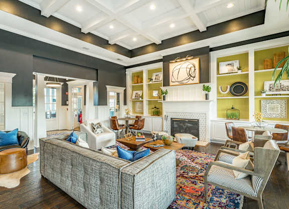A living room with a grey couch and a fireplace.