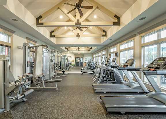 A spacious gym with treadmills, elliptical machines, and other exercise equipment.