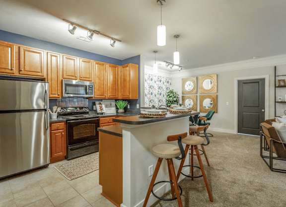 A kitchen with wooden cabinets and a stainless steel refrigerator.