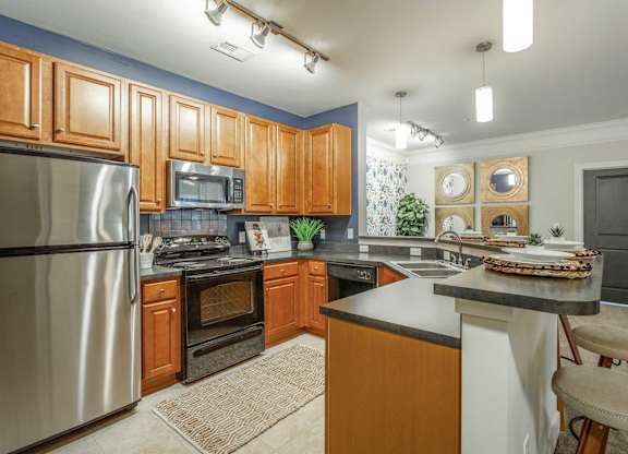 A kitchen with wooden cabinets and a stainless steel refrigerator.