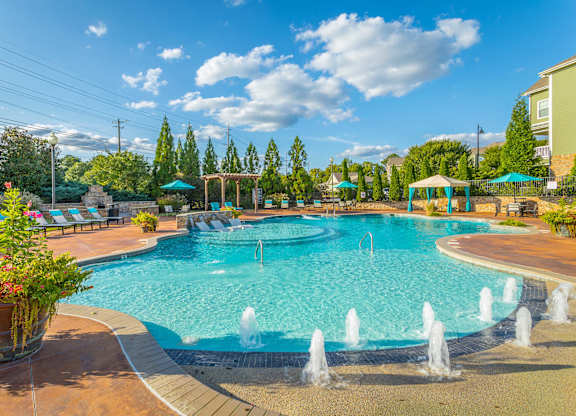 A large swimming pool with a fountain in the middle of it.