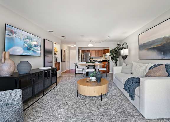 A living room with a grey carpet and a white sofa.