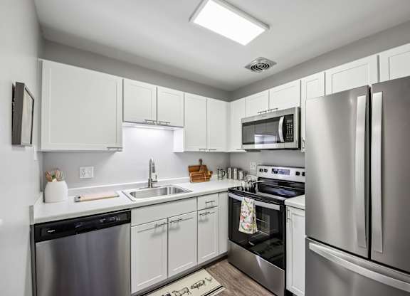 A modern kitchen with stainless steel appliances and white cabinets.