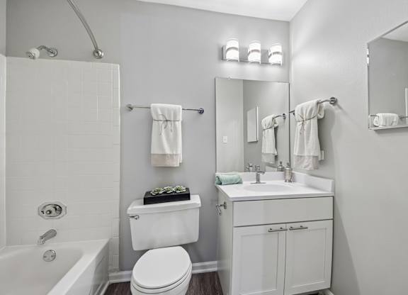 A white bathroom with a toilet, sink, and bathtub.