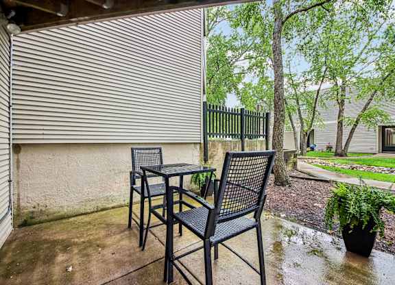 A patio with a table and two chairs.