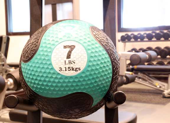 A green and black weighted ball with the number 7 on it.