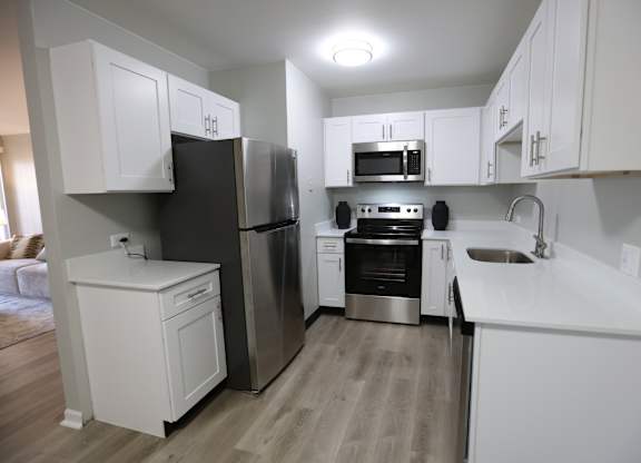 a kitchen with white cabinets and stainless steel appliances at Evergreen Luxury Apartments, Indiana, 46410