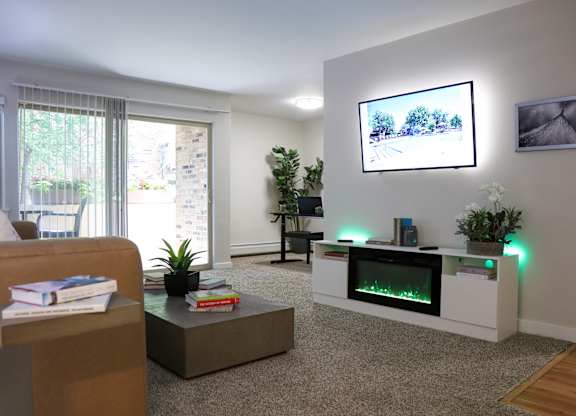 a living room with a fireplace and a tv on the wall at Fieldpointe of Schaumburg, IL, 60173