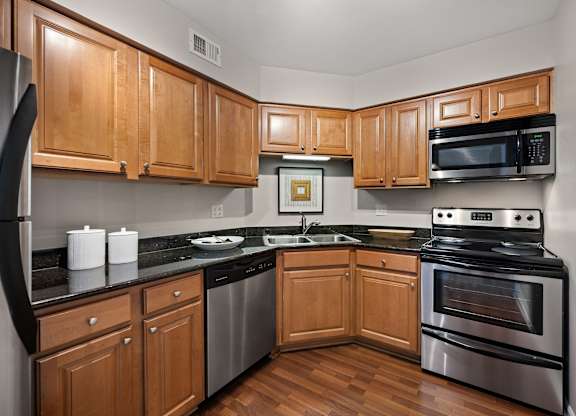 A kitchen with wooden cabinets and stainless steel appliances.