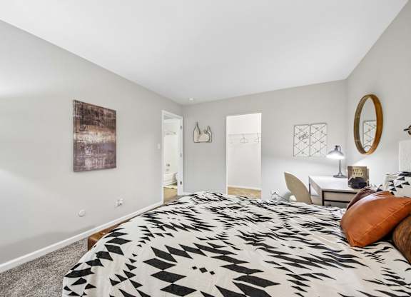 A bedroom with a large bed and a painting on the wall.