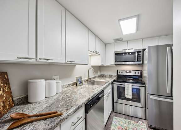 A kitchen with a refrigerator, oven, and microwave.