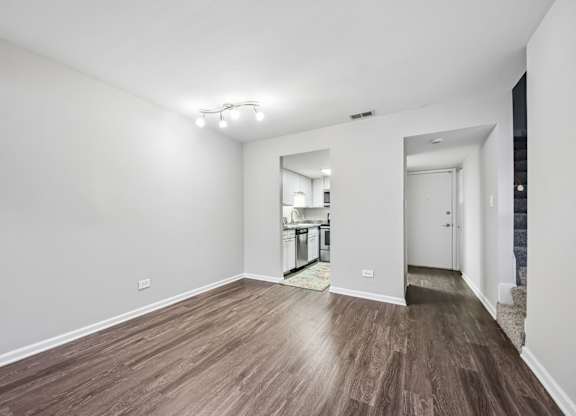 A room with wooden flooring and white walls.