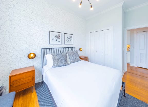 Cozy bed and lights in bedroom at Wells Place Apartments, Chicago, IL, 60607
