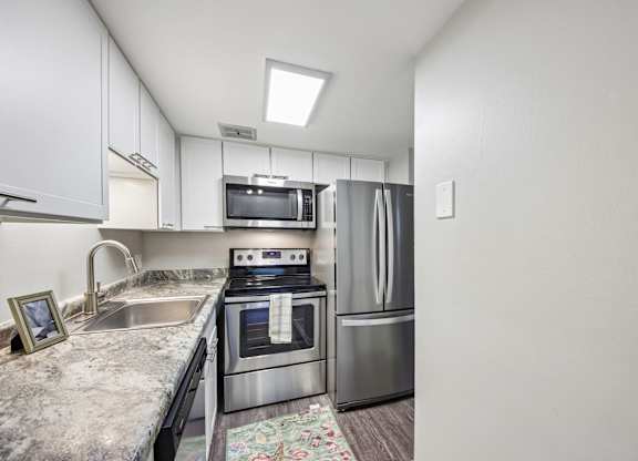 A kitchen with a stove, microwave, and refrigerator.