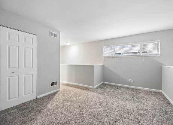 A room with a white door and carpeted floor.