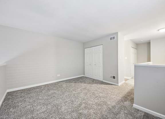 A room with a carpeted floor and a white door.