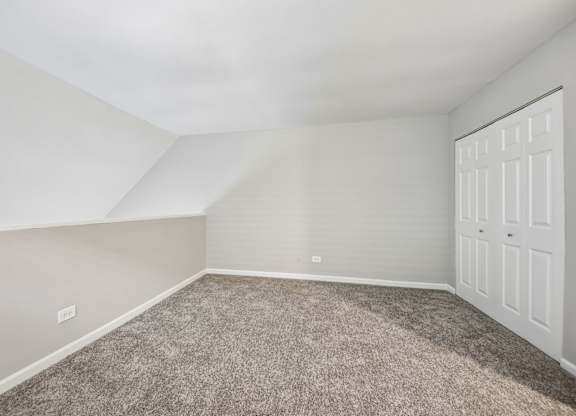 A room with a carpeted floor and a white door.
