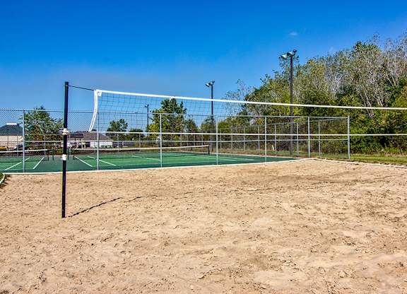A sandy beach volleyball court with a net and posts.